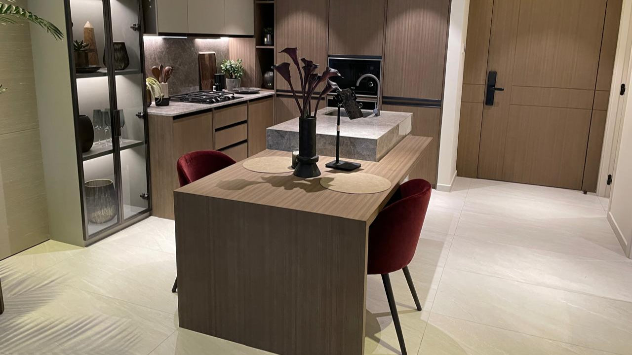Modern kitchen with a island and chairs in a well-lit room.